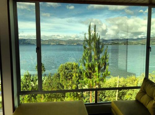 a view of a lake from a living room window at El Arca de Noah in Tota