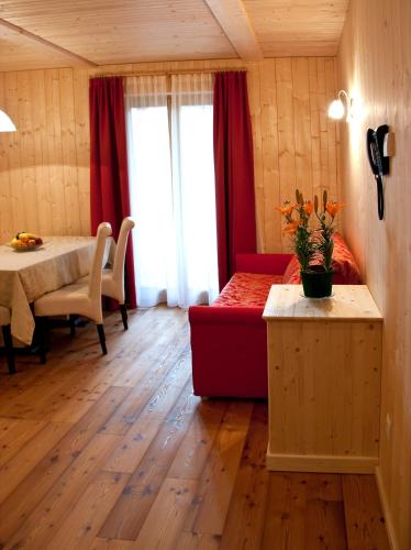 a living room with a red couch and a table at Appartments Helvetia in Villabassa