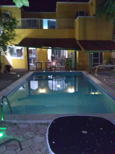 a swimming pool in front of a building at night at Yucatan Vista Inn Guest House in Mérida