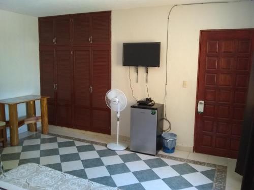 um quarto com uma ventoinha e uma televisão em Yucatan Vista Inn em Mérida