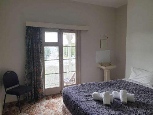- une chambre avec un lit, une fenêtre et une chaise dans l'établissement South Rakaia Hotel, à South Rakaia