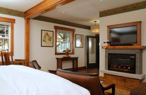 um quarto com uma cama, uma lareira e uma televisão em The Grand Idyllwild Lodge em Idyllwild