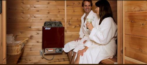 a man and a woman sitting in a sauna at The Grand Idyllwild Lodge in Idyllwild