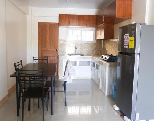 a kitchen with a table and a refrigerator at Gregorio Homes in Bauang