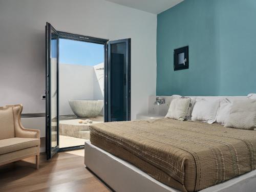 a bedroom with a large bed and a chair at Koufonisi Villas in Koufonisia