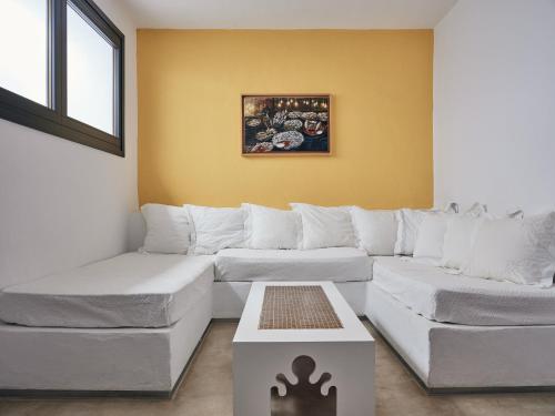 a living room with a white couch and a table at Koufonisi Villas in Koufonisia