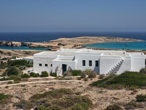 a white house on a hill with the ocean in the background at Koufonisi Villas in Koufonisia