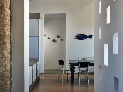 a dining room with a black table and chairs at Koufonisi Villas in Koufonisia