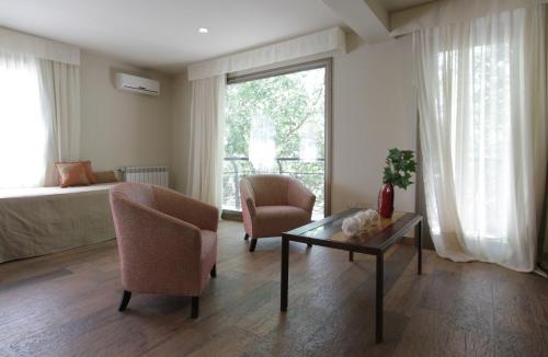 a living room with a bed and a table and chairs at Plaza Paradiso Petit Hotel in Chacras de Coria