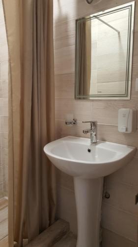 a bathroom with a white sink and a mirror at Prime Time Guest House in Kant