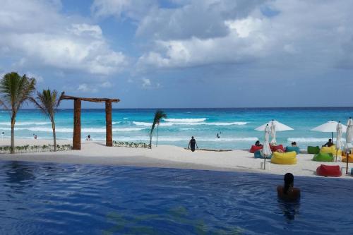 a person in a swimming pool next to a beach at Cancun, Ocean Dream, Beautiful Aparment, Heart of the Hotel Zone in Cancún