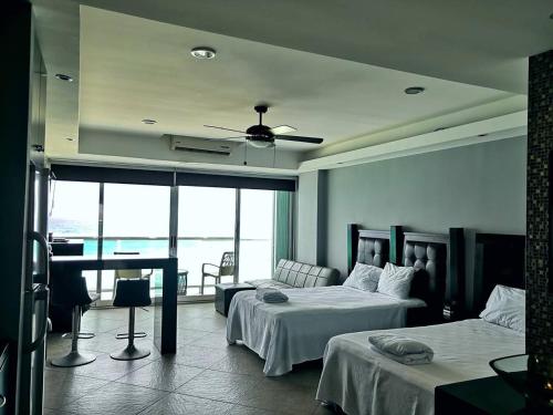 ein Hotelzimmer mit 2 Betten und einem Tisch mit Aussicht in der Unterkunft Cancun, Ocean Dream, Beautiful Aparment, Heart of the Hotel Zone in Cancún