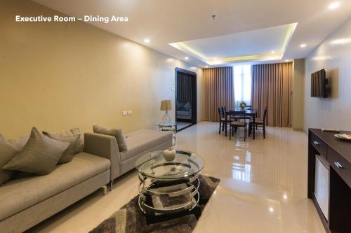 uma sala de estar com um sofá e uma área de refeições em Iloilo Gateway Hotel and Suites em Iloilo City