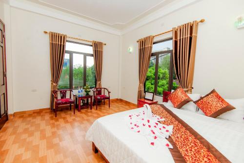 una camera con letto, tavolo e finestre di Tam Coc Cherry Homestay a Ninh Binh