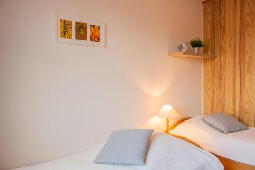 a bedroom with two beds and a picture on the wall at Haus am Deich Wohnung 11 in Dahme