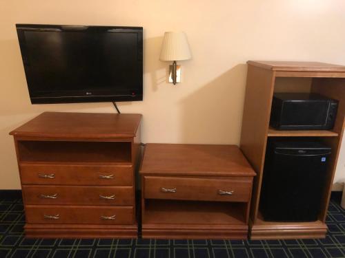 sala de estar con TV y tocador con tocador en Sunset Inn and Suites, en Seward