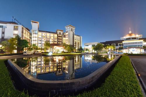 a large building with a pond in front of it at Summit Windmill Golf Suite Hotel at Suvarnabhumi in Bangna