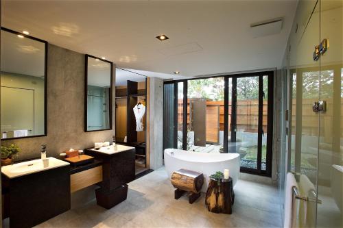 uma casa de banho com 2 lavatórios e uma banheira em Gaeavilla Resort em Jian