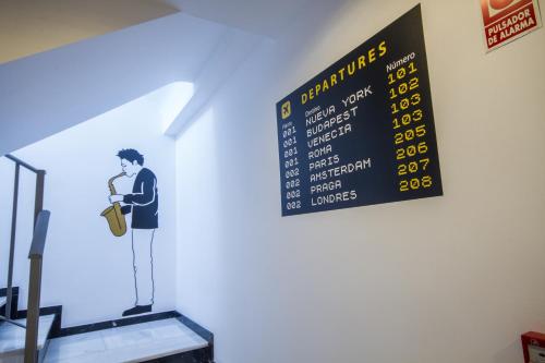 a sign on a wall with a man with a suitcase at Apartamentos El Templo Suites in Merida