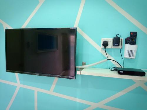a flat screen tv sitting on a shelf in a room at AZURE SKY HOMESTAY KUALA SELANGOR in Kuala Selangor