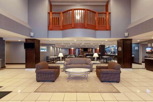 a lobby with chairs and a table in a hotel at Wingate by Wyndham Erie in Erie