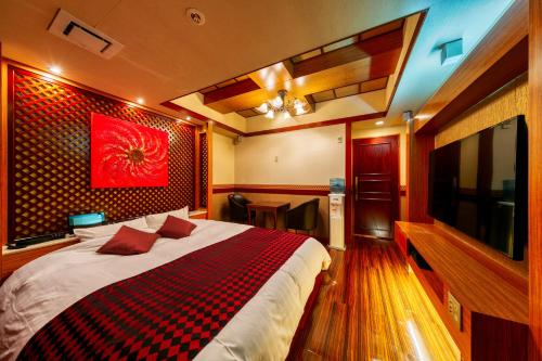 a bedroom with a large bed and a television at Hotel Lotus Otsu (Adult Only) in Otsu