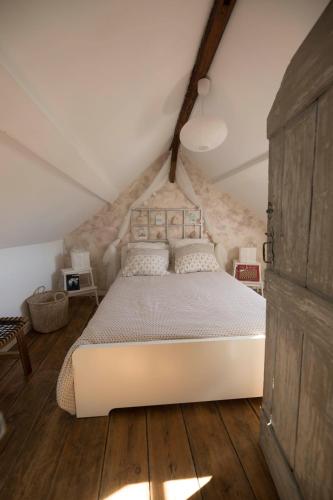 une chambre avec un grand lit dans un grenier dans l'établissement Atelier 39bis, à Honfleur