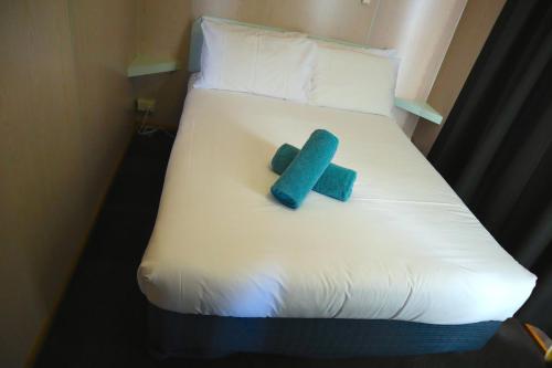 a bed with a blue and white blanket and pillows at BIG4 Ulverstone Holiday Park in Ulverstone