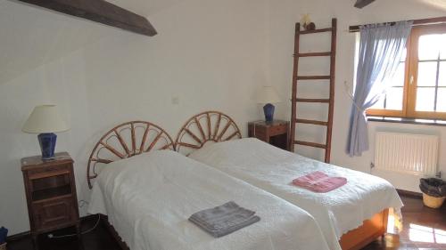 een slaapkamer met een wit bed en 2 handdoeken bij Gîte Hyrom 5 Places Moulin de la Placette in Faye-dʼAnjou