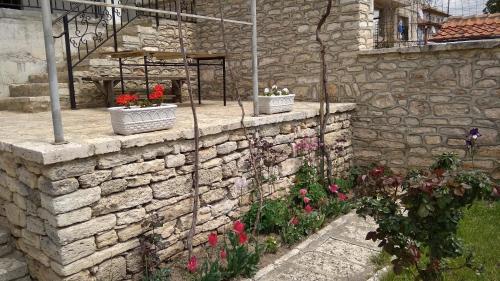 una pared de piedra con dos plantas y flores en Casa de Elgo en Balchik