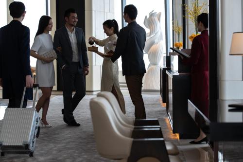 a group of people standing in a lobby at Jumeirah Nanjing Hotel in Nanjing