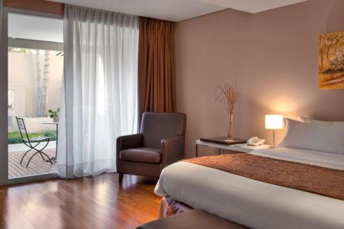 a hotel room with a bed and a chair at San Isidro Plaza Hotel in San Isidro
