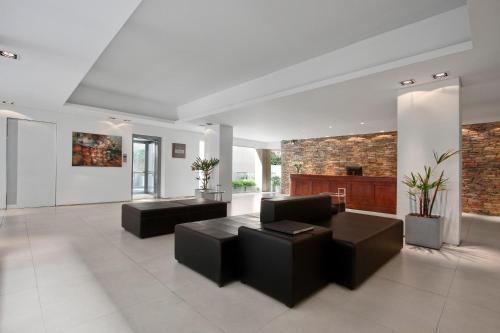 a living room with black furniture and a brick wall at San Isidro Plaza Hotel in San Isidro