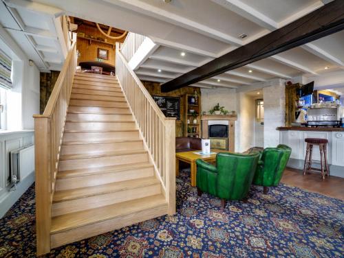 
a green staircase leading to a room filled with furniture at The Swan Hotel in Wadebridge
