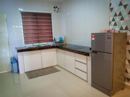 a kitchen with a sink and a refrigerator at AZURE SKY HOMESTAY KUALA SELANGOR in Kuala Selangor