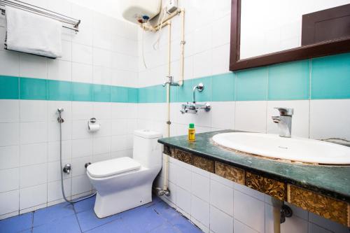 a bathroom with a toilet and a sink at Hotel Ashrey in Dehradun