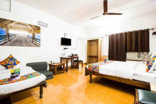 a hotel room with two beds and a tv at Hotel Ashrey in Dehradun
