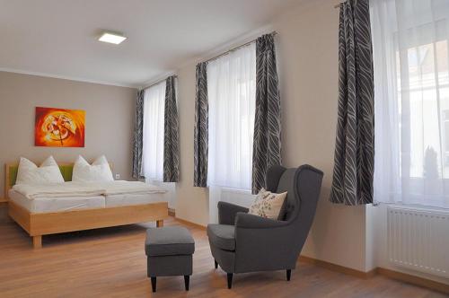a bedroom with a bed and a chair and a couch at Bed Bike & Breakfast in Traismauer