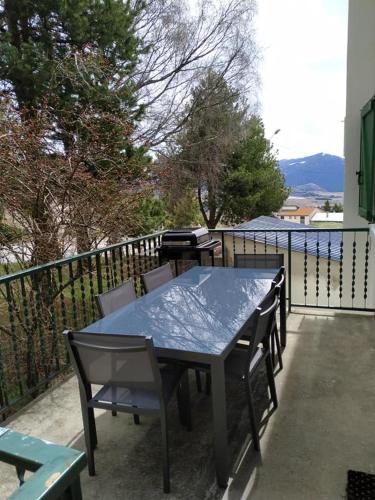 - une table et des chaises sur une terrasse avec barbecue dans l'établissement F3 Terrasse & Jardin Font-Romeu, à Font-Romeu-Odeillo-Via