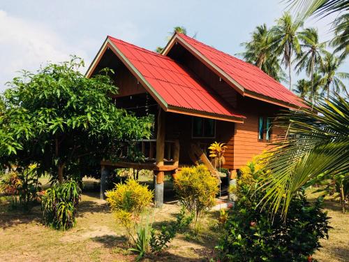 ein kleines Holzhaus mit rotem Dach in der Unterkunft Gardenhomeresortkohjum in Ko Jum