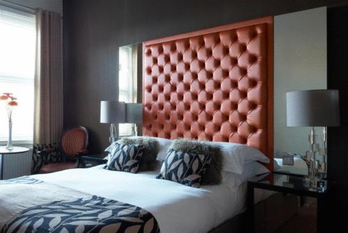 a bedroom with a large bed with a red headboard at Hastings House in Hastings