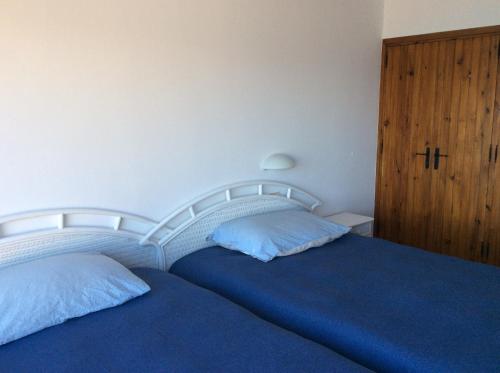 a bedroom with two beds with blue sheets and a wooden cabinet at Cap Sa Sal Navy, Begur, Girona in Begur