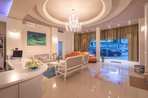 a living room with a chandelier and a dining room at PALMA city HOTEL in Sarandë