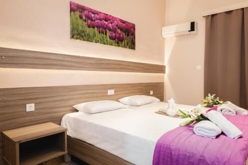 sypialnia z 2 łóżkami i różowymi tulipanami w obiekcie Pavlos studios w Laganas
