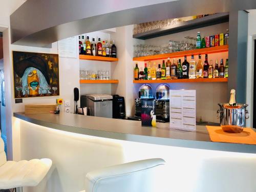 a bar with a counter and some bottles of alcohol at Boutique Hôtel d'Orbigny Chatelaillon - La Rochelle in Châtelaillon-Plage