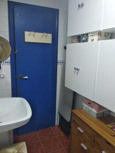 a blue door in a bathroom with a sink at O Pazo in O Grove
