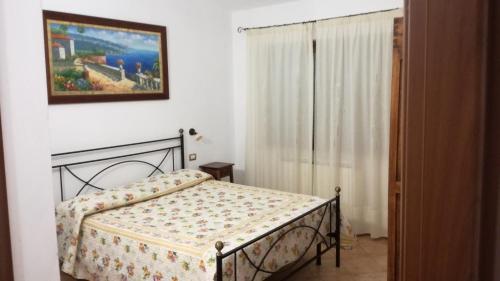 Agriturismo cavallin del papa في كابالبيو: غرفة نوم بسرير وصورة على الحائط