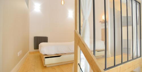 a small bedroom with a bed and a staircase at Appart' Neyret in Lyon