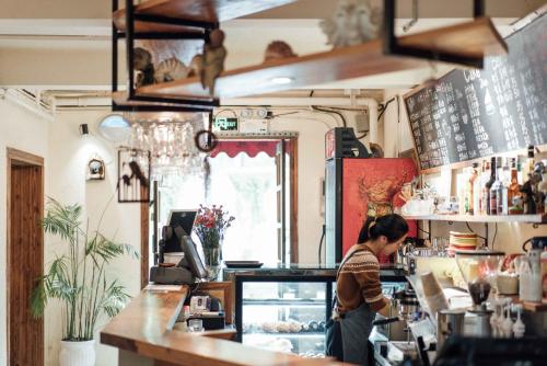 una mujer parada en el mostrador de una cafetería en Lao men dong International Youth Hostel en Nanjing