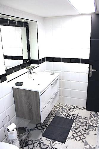 une salle de bain avec un lavabo et un miroir dans l'établissement Le Duplex du Mole, à Sète